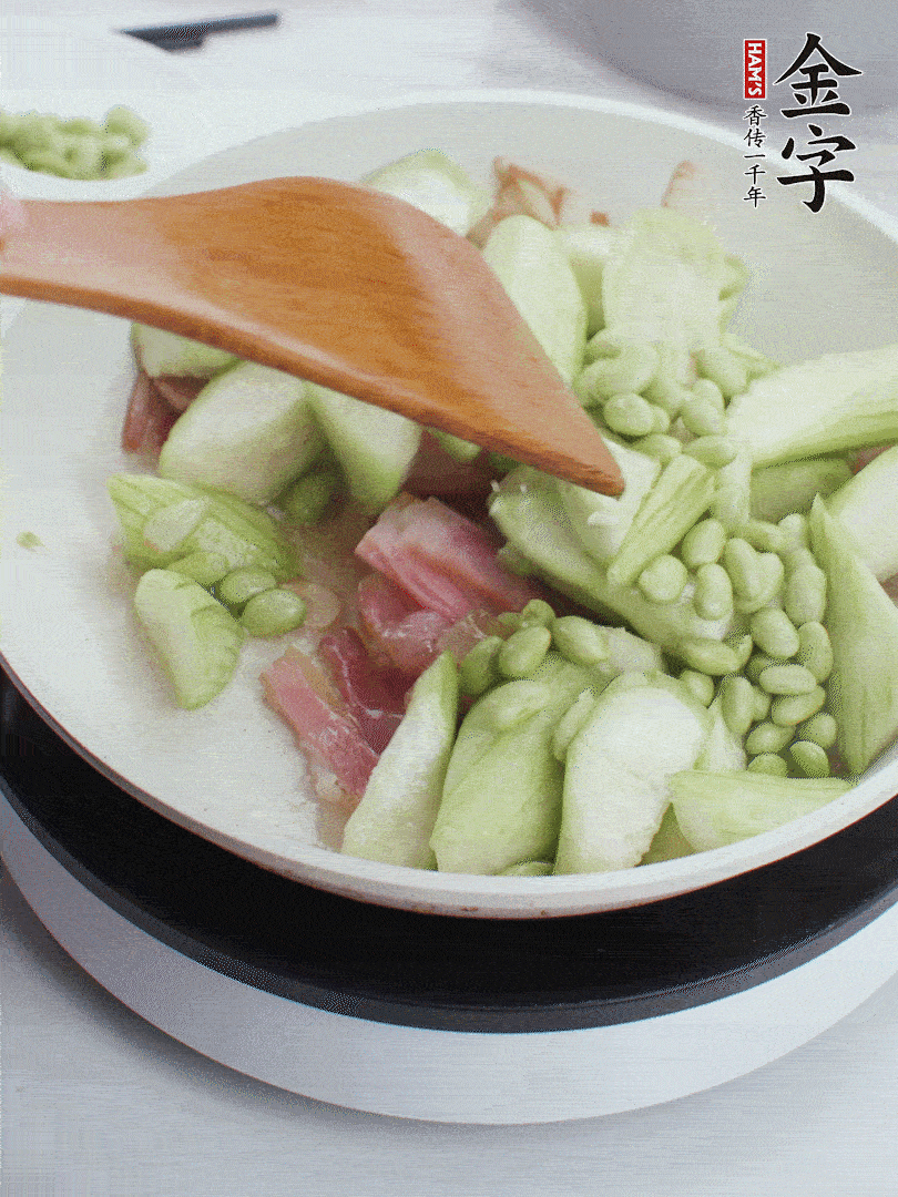 依次下絲瓜、青豆翻炒，炒至絲瓜打蔫縮小。